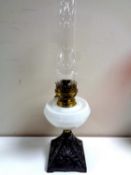 An English Search oil lamp on cast iron base with opaque reservoir and chimney