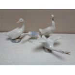A Lladro figure of a goose in flight together with three further Spanish figures of geese.