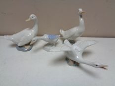 A Lladro figure of a goose in flight together with three further Spanish figures of geese.