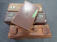 Two vintage leather luggage cases and two further luggage cases bearing shipping labels