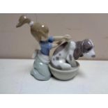 A Lladro figure of a girl washing hound in tub.