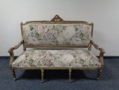 A French carved gilt wood settee in floral upholstery