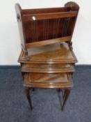 A nest of three walnut glass top tables together with a mahogany magazine rack with lion mask