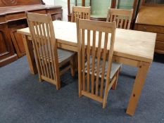 A stripped pine kitchen table together with four chairs