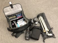 A Canon 350D digital camera in case with accessories together with a Sigma lens and a camera tripod