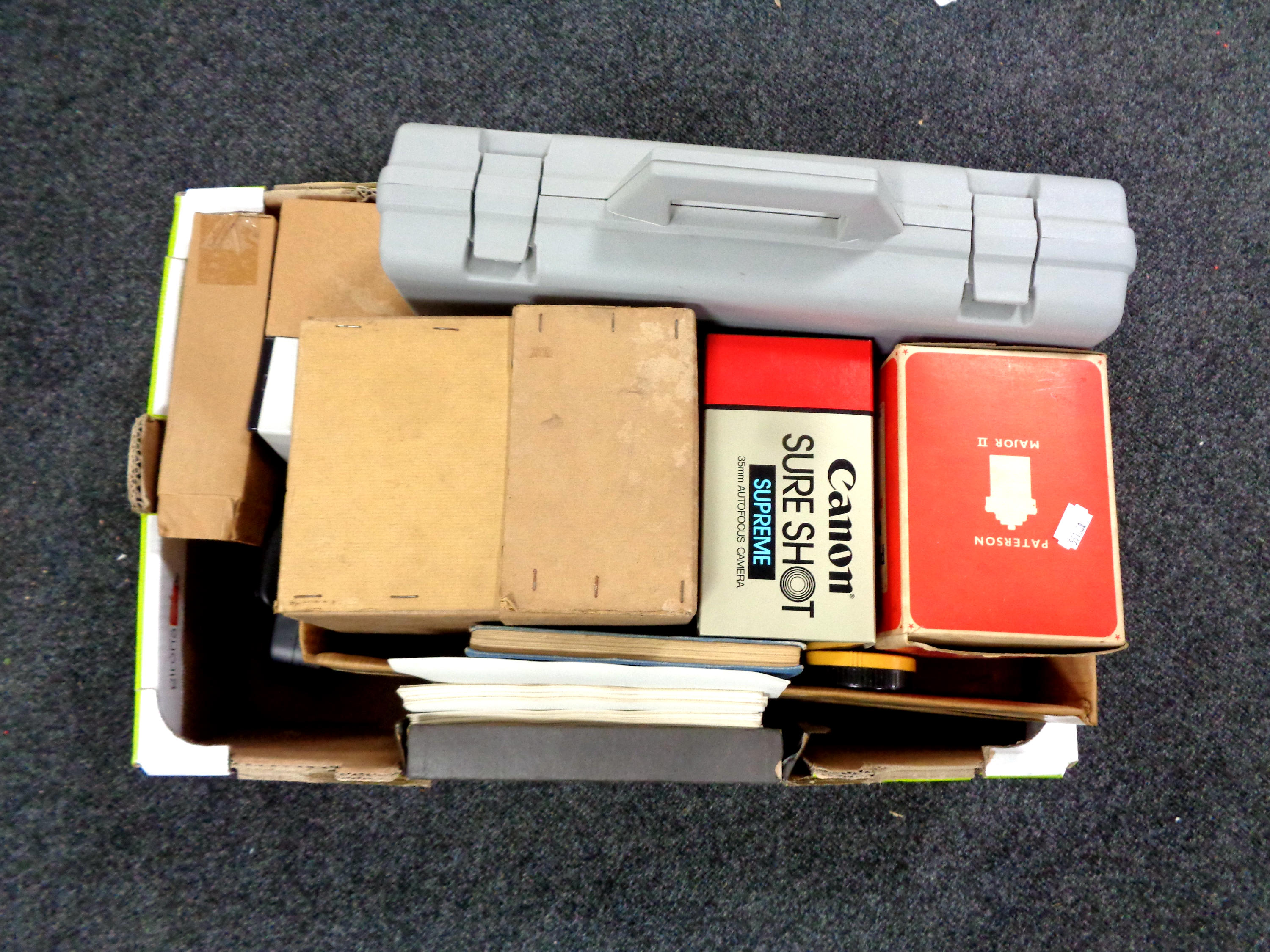 A box containing camera equipment, German language tapes,