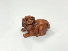 A carved Chinese hardwood netsuke - Lion seated