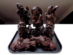 A tray containing a pair of Chinese carved hardwood figures of water buffalo (as found) together