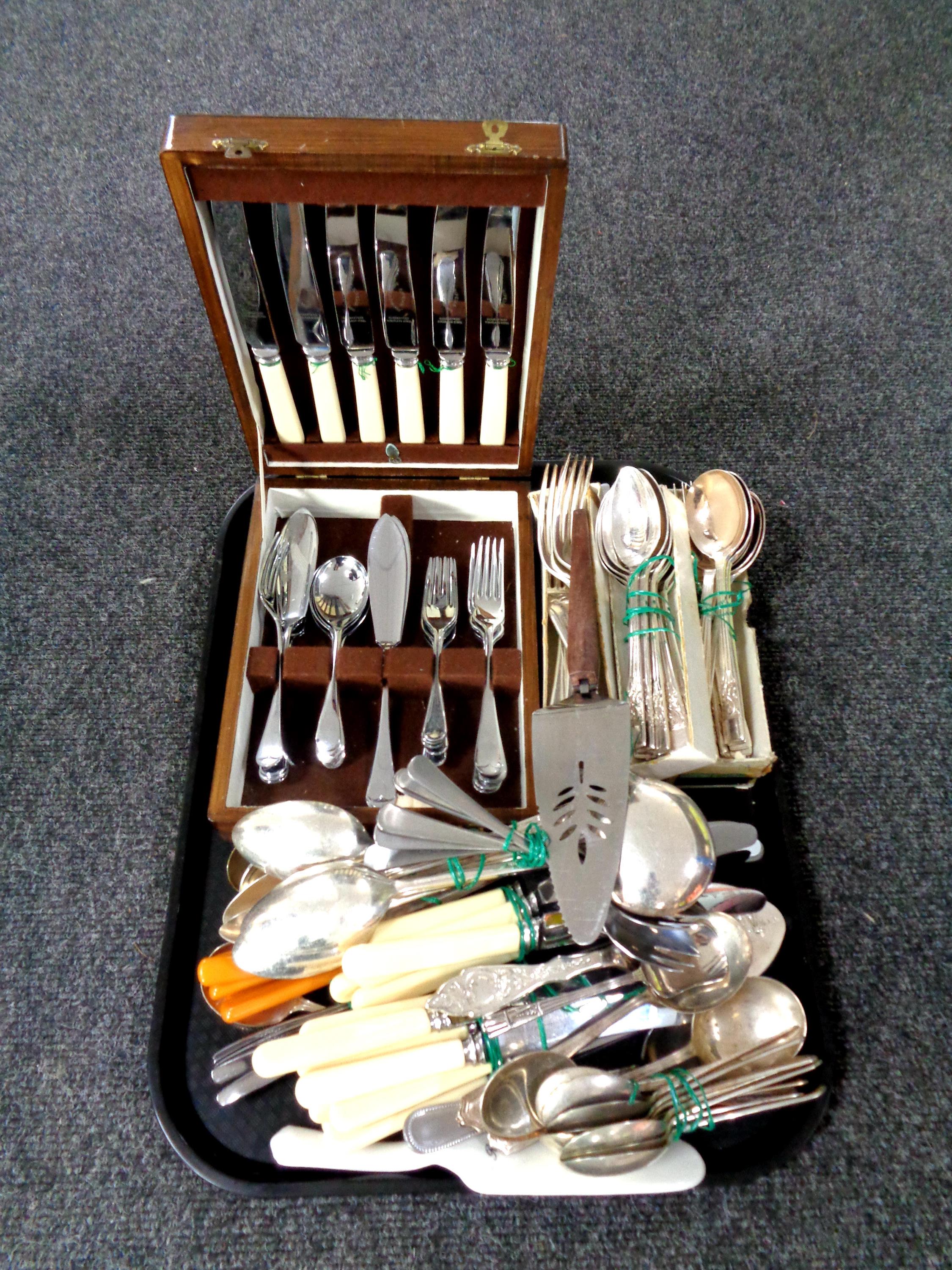A tray containing a quantity of boxed and unboxed cutlery