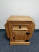 A pine single door single drawer cabinet fitted magazine rack either side