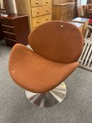 A retro swivel chair on polished metal base