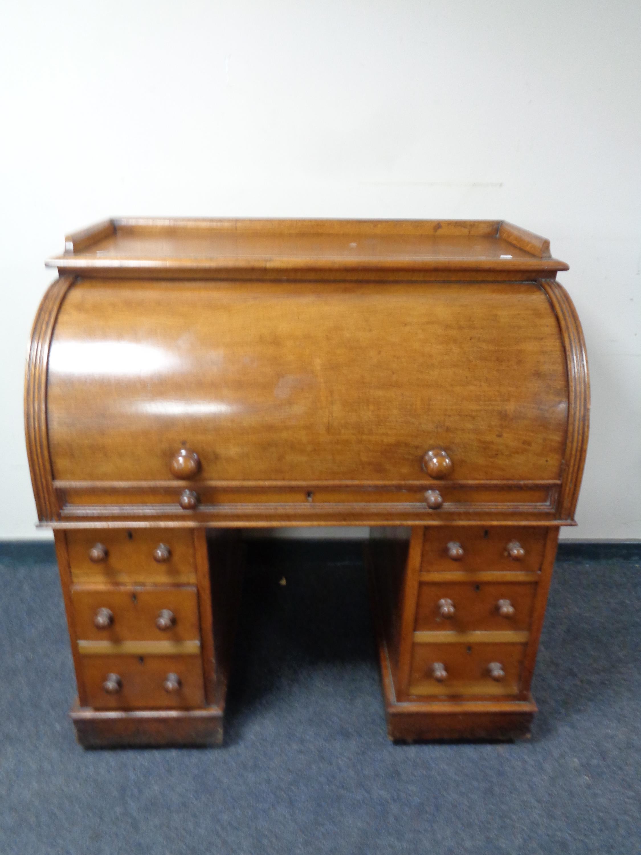 An Edwardian oak cylinder front bureau with fitted interior