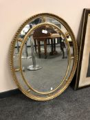 An early 20th century oval gilt framed mirror,