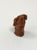 A carved Chinese hardwood netsuke - Gentleman holding a club