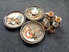 A box containing German pottery beer steins and three similar wall plates