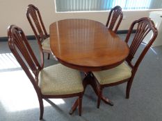 A yew wood twin pedestal dining table and four chairs