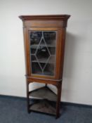 An Edwardian inlaid mahogany cabinet on stand with leaded glass door