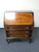 A walnut writing bureau fitted three drawers on cabriole legs