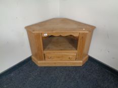 A stripped pine corner television stand fitted a drawer