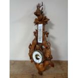 A late 19th century Black Forest carved oak hunting-themed barometer