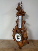 A late 19th century Black Forest carved oak hunting-themed barometer