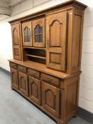 A 20th century oak dresser fitted eight cupboards and four drawers with brass bow handles,