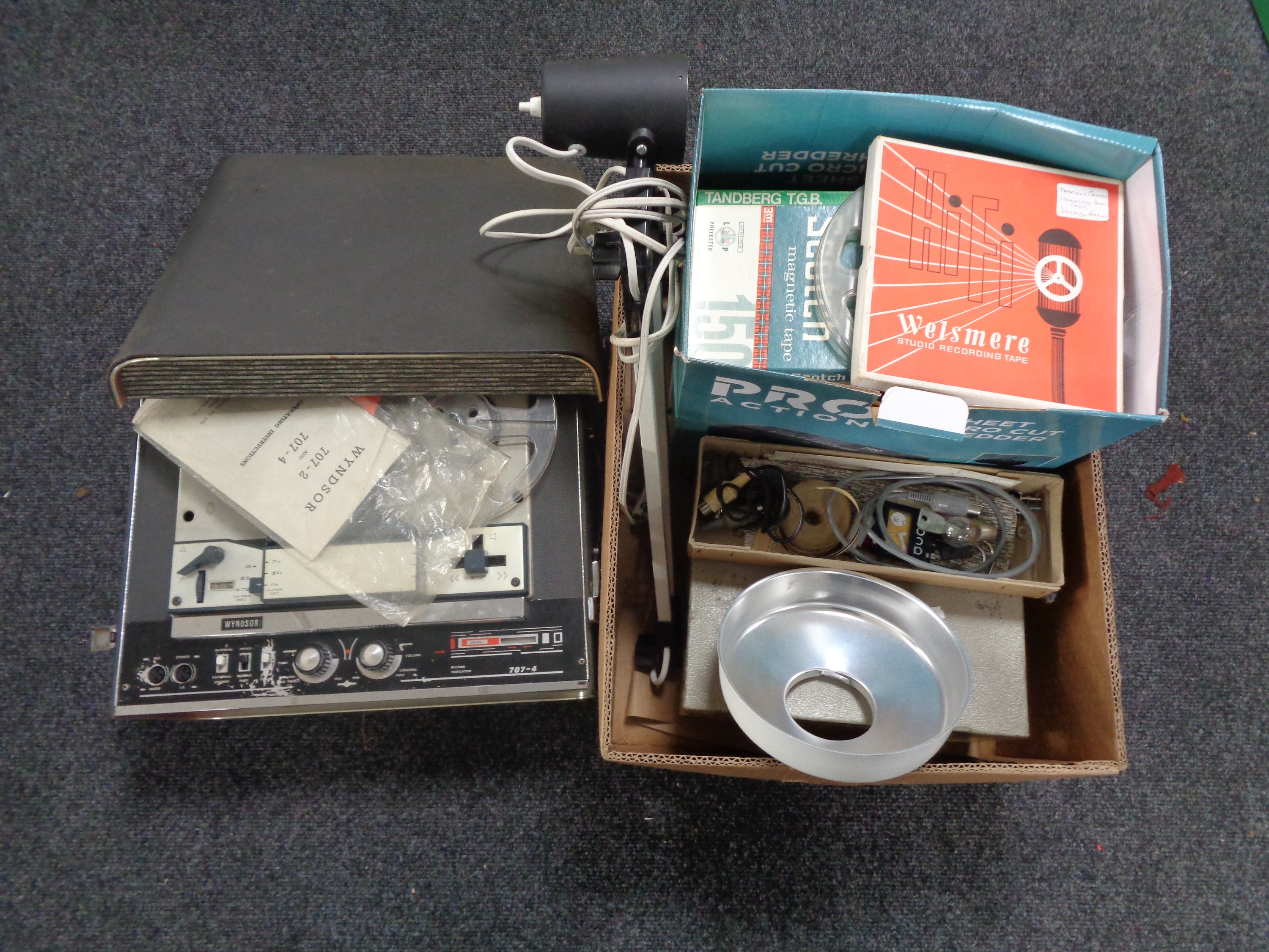 A Wyndsor reel to reel player together with a box containing recording tapes,