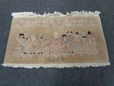 A fringed Chinese rug depicting figures