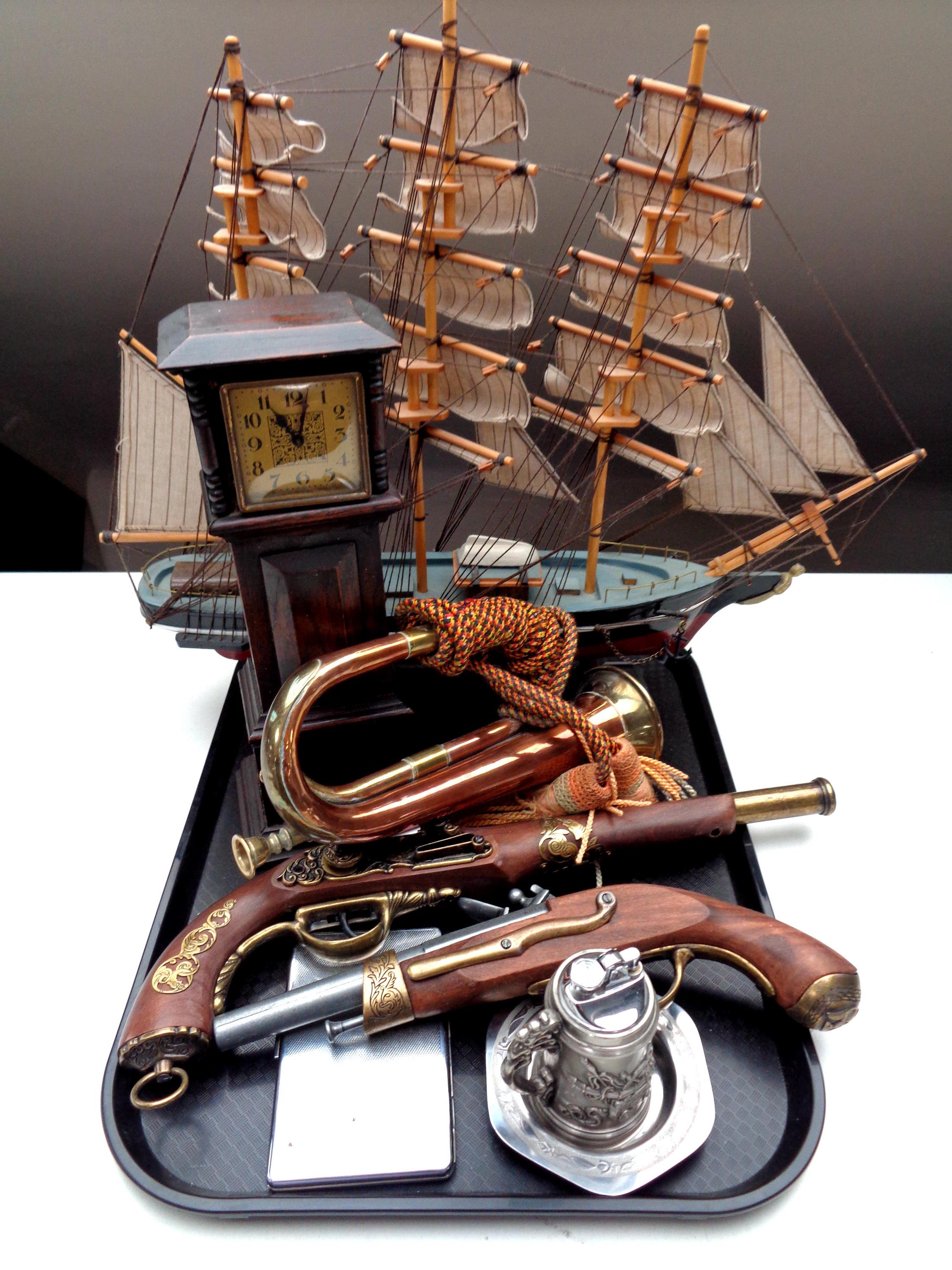 A tray containing model of a three masted sailing ship, copper and brass bugle,