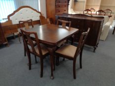 A walnut extending table and four chairs and matching sideboard