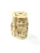 A carved Chinese bone netsuke - Gentleman holding staff and money bag