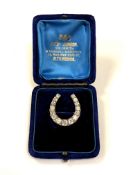 A late Victorian diamond set horseshoe brooch, set with fifteen graduated old-cut stones,