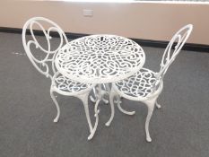 A painted cast metal patio table and two chairs