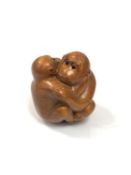 A carved Chinese hardwood netsuke -Two monkeys embracing