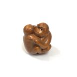 A carved Chinese hardwood netsuke -Two monkeys embracing