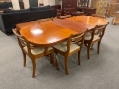 A reproduction twin pedestal extending table with leaf and six chairs