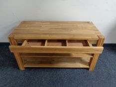 A contemporary oak table fitted two shelves beneath