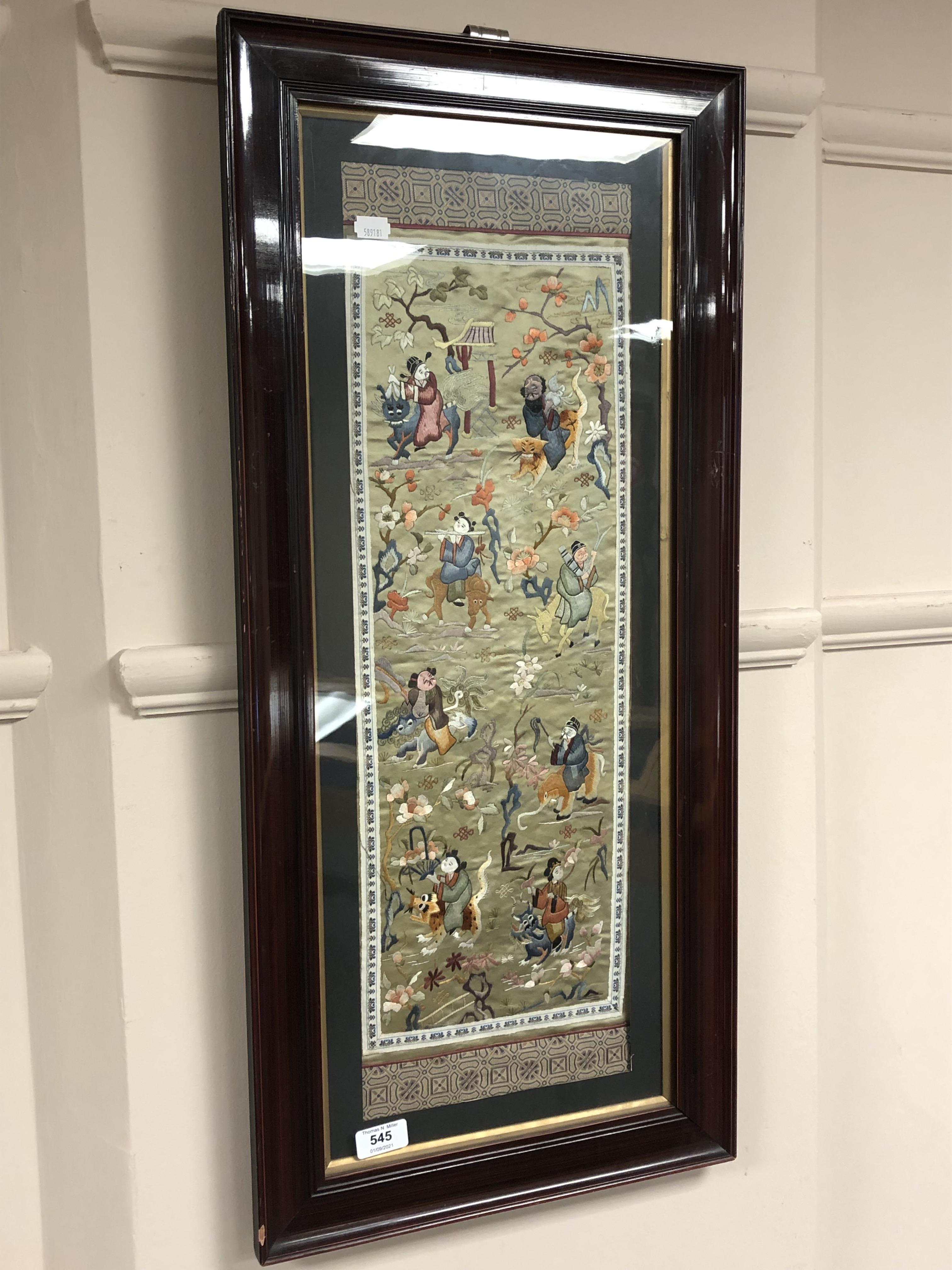 A 20th century Japanese embroidered panel depicting figures riding animals,