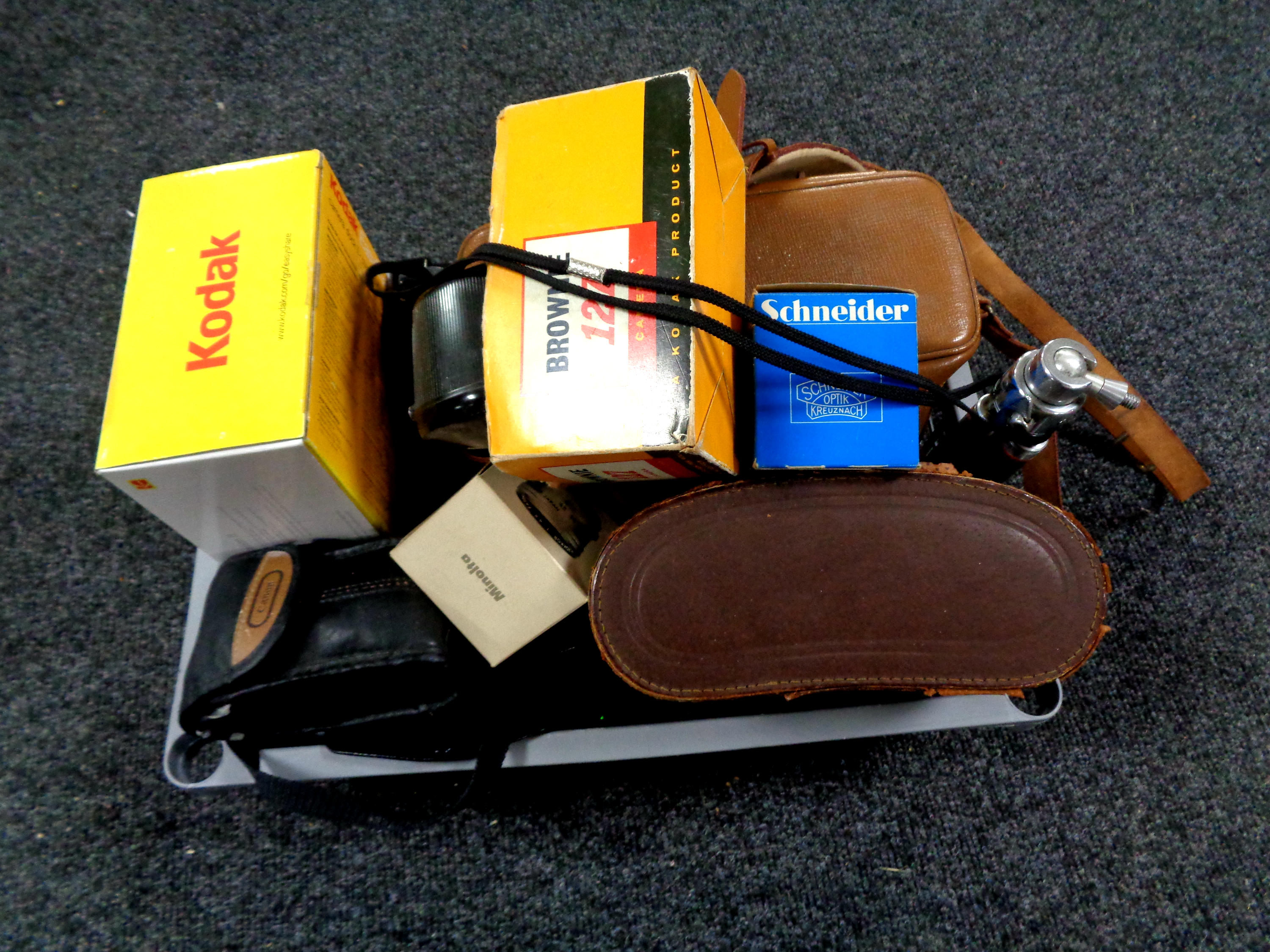 A crate containing a large quantity of cameras and camera accessories,