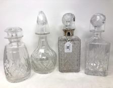 A cut glass decanter with silver collar, together with three further glass decanters.