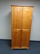 A contemporary pine double door wardrobe