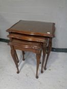 A nest of three mahogany glass topped tables together with two wine tables