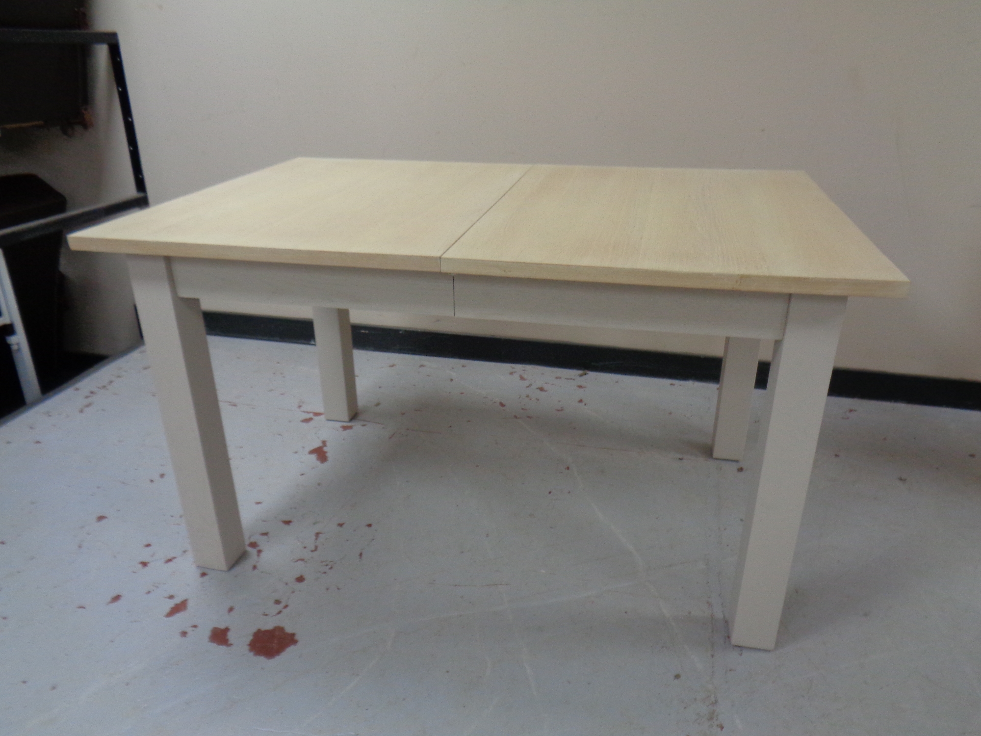 An extending dining table on painted base