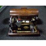 A vintage cased Singer hand sewing machine