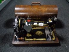 A vintage cased Singer hand sewing machine