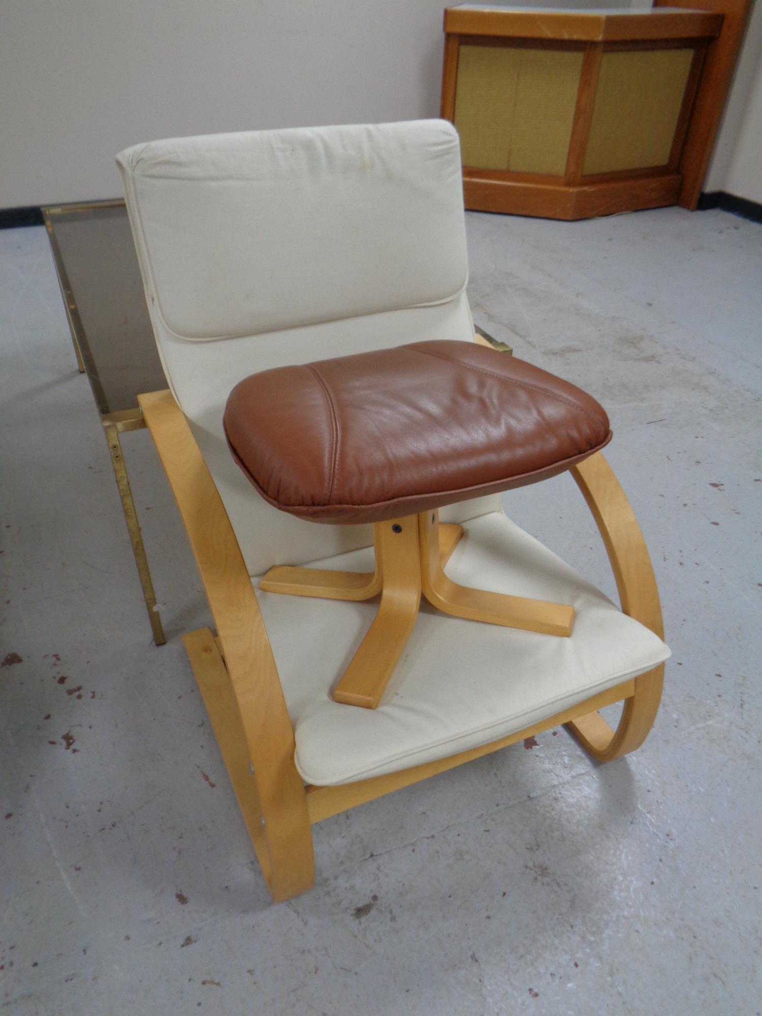 A beech framed relaxer armchair together with a leather footstool