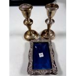 A pair of silver candlesticks together with a silver photo frame