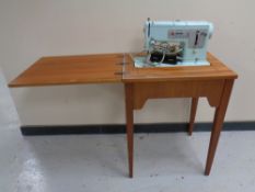 A 20th century Singer electric sewing machine in teak table