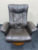 A brown leather swivel relaxer armchair on wooden base