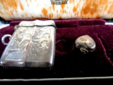 A silver vesta case together with a silver heart shaped locket